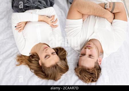 thoughtful family lying on the bed. close up top view photo. couple keeping the silent. peace Stock Photo