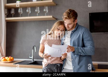 surprised unhappy couple has informed about debt. young people have problems with bank. close up photo Stock Photo