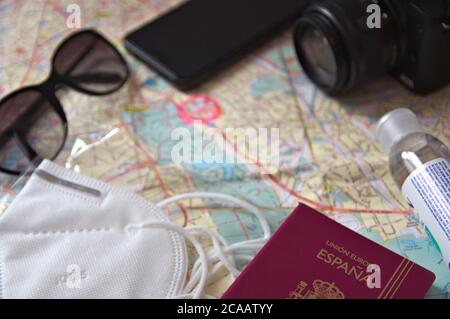 Conceptual image about times of pandemic with a mask, a map, a camera, some sunglasses and a Spanish passport Stock Photo