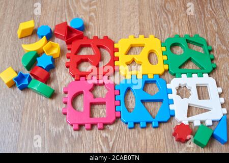 Educational colorful toy sorter with different shapes on a wooden background. Stock Photo