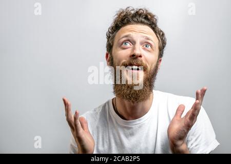 Happy middle-aged handsome man giving thanks to God for a successful marriage and healthy kids , spreading hands with a smile in thanksgiving, body la Stock Photo