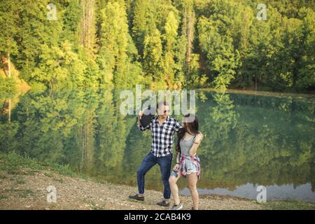 young joyful people are strolling on the lakeside. picnic with girlfriend concept Stock Photo