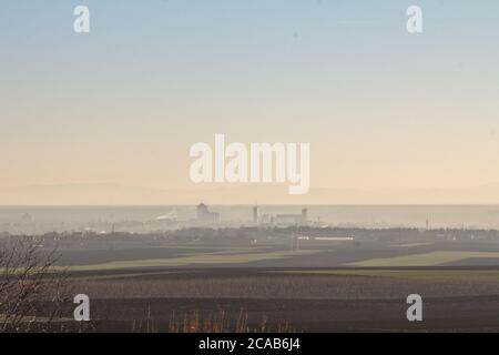 Panorama of the city of Sid, seen frol above, during a foggy dusk, in winter, surrounded by agricultural fields. Sid is a city of Serbia, near the Cro Stock Photo