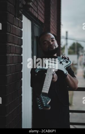 African American man with guitar on terrace in Kentucky Stock Photo