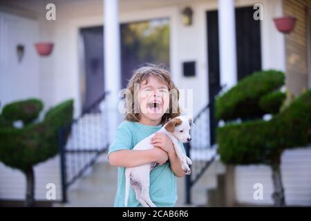 Protection of animals. Happy little kids playing with dog in garden. Stock Photo