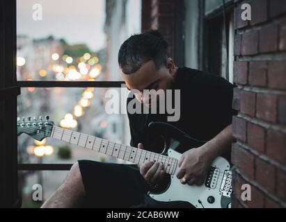 African American man with guitar on terrace in Kentucky Stock Photo