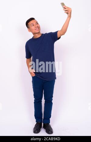 Portrait of happy young Asian man taking selfie Stock Photo