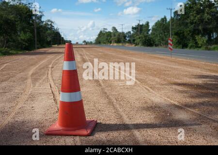 Red rubber cone is placed on the road during the construction of the road. Stock Photo