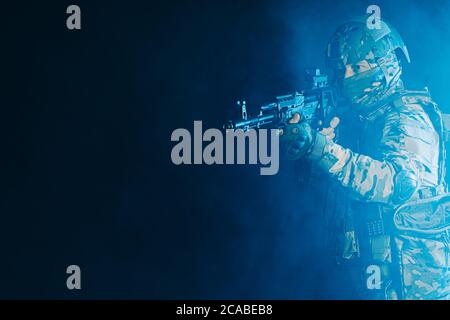 courageous soldier man in green military wear holding gun, rifle in hands, don't afraid of danger, looking for enemy Stock Photo