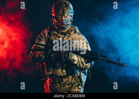 powerful and strong military man in military forces wear and helmet pointing rifle at enemy, ready to shoot, fight for country, isolated in ultra viol Stock Photo