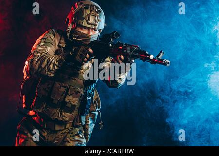 courageous soldier man in green military wear holding gun, rifle in hands, don't afraid of danger, looking for enemy Stock Photo