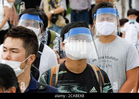 Hiroshima, Japan. 6th Aug, 2020. People wearing face shields line up to pray for the atomic bombing victims at the Peace Memorial Park. Local authorities implemented measures to prevent the spreading of the new coronavirus during the annual memorial ceremony at the Peace Memorial Park in Hiroshima. This year marks the 75th anniversary of the atomic bombing in Hiroshima and Nagasaki by the United States during World War II. Credit: Rodrigo Reyes Marin/ZUMA Wire/Alamy Live News Stock Photo