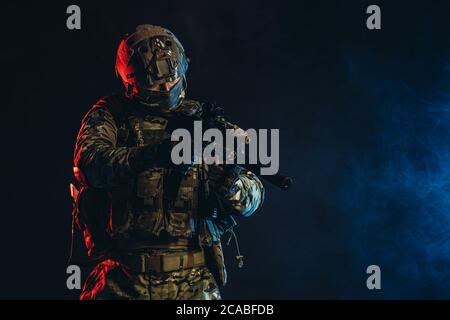 brave strong and confident man soldier wearing army clothes, green camouflage stand holding gun, ready to shoot Stock Photo