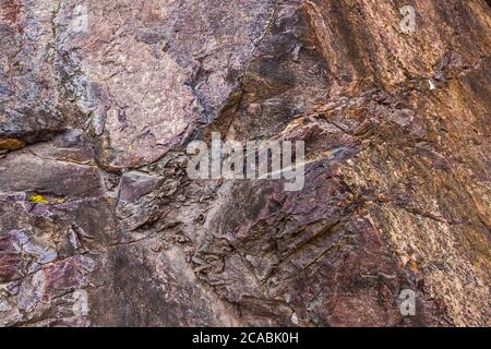 Closeup of dark dged shabby cliff cracks. Gray stone rock texture of mountains. Concept of geology and mountaineering Stock Photo
