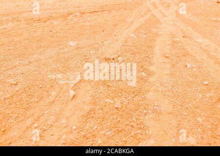 Wheel tracks in extremely dry light brown dusty clay soil as texture Stock Photo