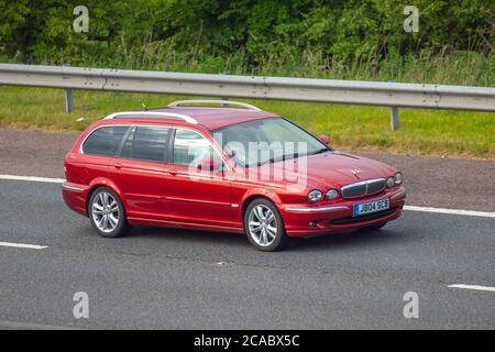 2007 red Jaguar X-Type Sovereign D; Vehicular traffic moving vehicles, cars driving, vehicle on UK roads, motors, motoring on the M6 motorway highway network. Stock Photo