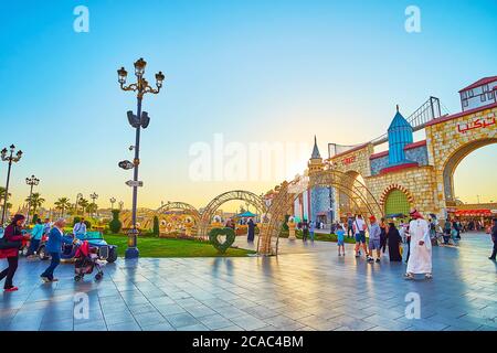 DUBAI, UAE - MARCH 5, 2020: The sunset sky over the grounds of Global Village Dubai with trade pavilions, arched alley and floral installations on the Stock Photo