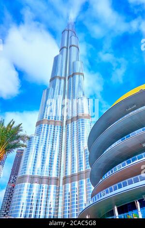 DUBAI, UAE - MARCH 3, 2020: The side of Dubai Mall shopping center and the highest Barj Khalifa building in clouds, on March 3 in Dubai Stock Photo