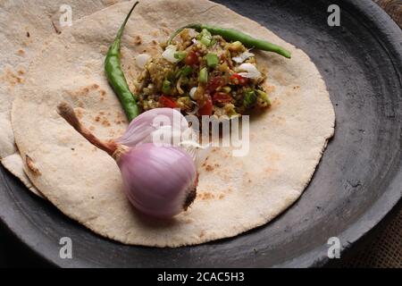 Baigan/Baingan Bharta - Mashed roasted Eggplant cooked with spices & vegetables. Served with Jowar flour flat bread known as bhakar/bhakri. Stock Photo