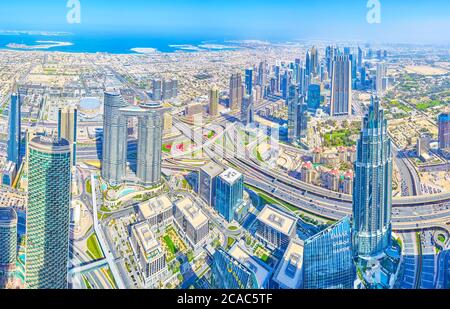 DUBAI, UAE - MARCH 3, 2020: The scenic aerial cityscape from the top of Burj Khalifa tower with modern skyscrapers and residential houses with seashor