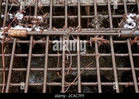 Iron grate for draining water in the city. Old drain ditch. Stock Photo