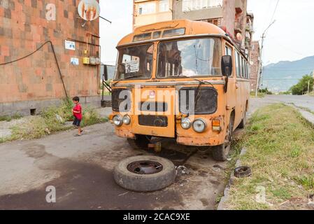 Alaverdi / Armenia - July 20, 2019: Soviet style buildings and broken bus in Alaverdi Stock Photo