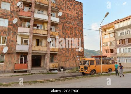 Alaverdi / Armenia - July 20, 2019: Soviet style buildings and broken bus in Alaverdi Stock Photo