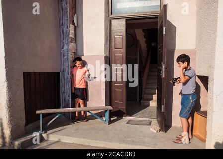 Sukhumi / Abkhazia - August 2, 2019: children playing robbing door of a house with water pistols Stock Photo