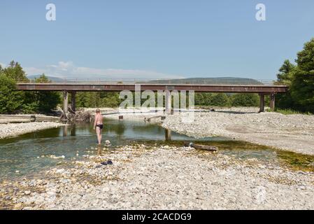 Sukhumi / Abkhazia - August 2, 2019: man bathing in shallow river with dog Stock Photo