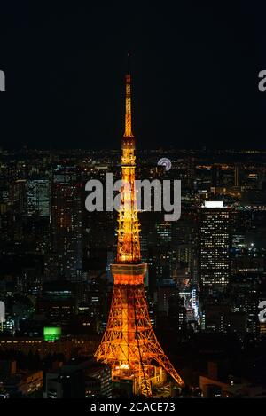 Cityscape of Tokyo at night, as seen from the top of one of the highest buildings in Roppongi Hills, with the illuminated Tokyo Tower glowing. Stock Photo