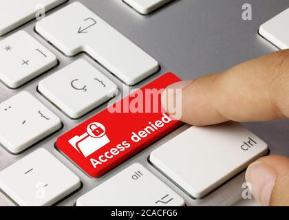 Access denied Written on Red Key of Metallic Keyboard. Finger pressing key. Stock Photo