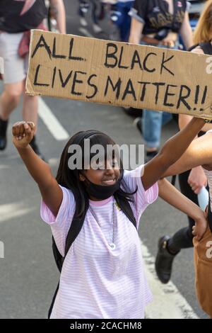 A protester holds up a clenched fist Friday, Aug. 15, 2014, in front of ...