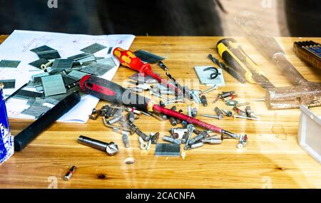 desktop in the workshop, tools lie on the table in the workshop. workshop table behind glass Stock Photo