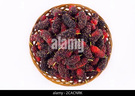ripe mulberry in  brown basket is a fruit with vitamins. on white background healthy mulberry fruit food isolated Stock Photo