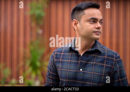 Portrait of young handsome Indian businessman outdoors Stock Photo