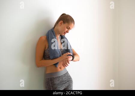 young fit woman in sportswear checking the smartwatch - sport gadgets and smart technology concept Stock Photo