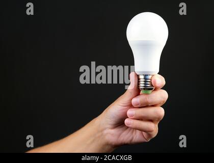 Led energy-saving light bulb in the hand of a person. The concept of modern economical lighting Stock Photo