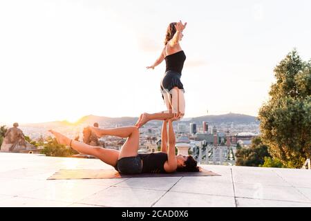 Two beautiful women doing acroyoga in the city Stock Photo