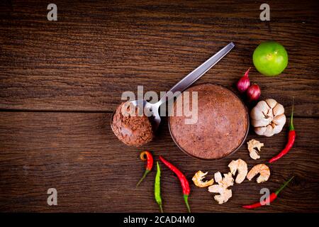 top view of  Shrimp Paste ( kapi ) and thai ingredient  in glass bowl on wooden background. Stock Photo