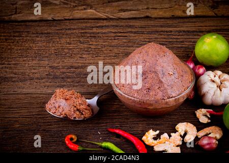 shrimp paste ( kapi ) and ingredient on brown wood texture background. Stock Photo