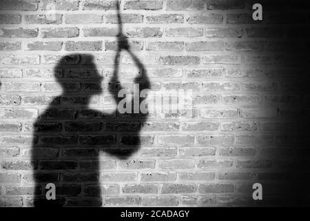 Shadow of sad man hanging suicide. light and shadow Stock Photo