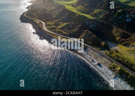 Causeway Coastal Route a.k.a Antrim Coast Road A2 on the Atlantic coast in Northern Ireland. One of the most scenic coastal roads in Europe. Aerial vi Stock Photo