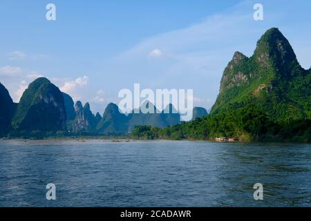 Beautiful view of Lijiang ( Li river ) in Guilin City Guangxi China. Green forest mountains above peaceful blue river. Karst landform. Stock Photo