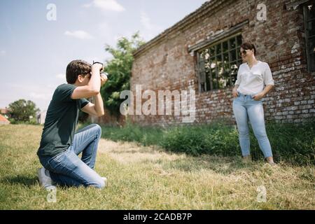 Male photographer photographing a female model in village Stock Photo
