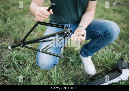 Close-up view of man's hands setting camera stand Stock Photo