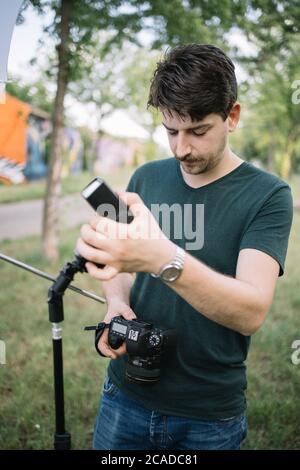 Man holding camera and preparing for outdoor photo session Stock Photo