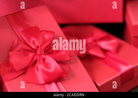 close up heap of bright red gift boxes with ribbon bow. Blur background Stock Photo