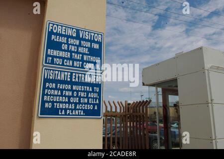 Matamoros, Mexico April, 2006: Bilingual signs outside a maquiladora manufacturing plant across the United States border from Brownsville, Texas.  ©Bob Daemmrich Stock Photo