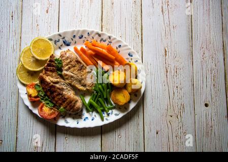 Steak meat and vegetables in a plate on a background Stock Photo