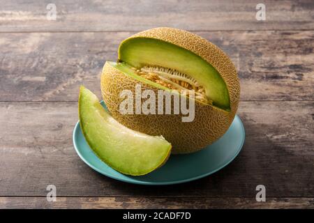 Yellow cantaloupe melon fruit on wooden table Stock Photo